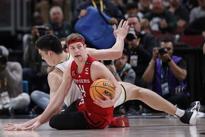 Scarlet Knights guard Paul Mulcahy (4) looks to pass the ball away from Purdue Boilermakers center Zach Edey (15) during the first half at United Center.